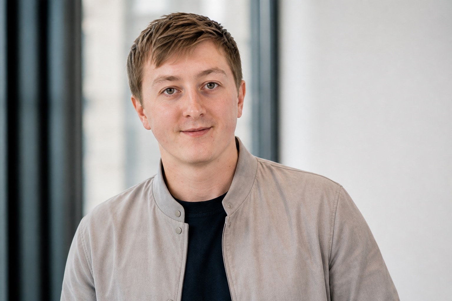 Moritz Zinecker in einer hellgrauen Jacke in einem hellen Arbeitsumfeld